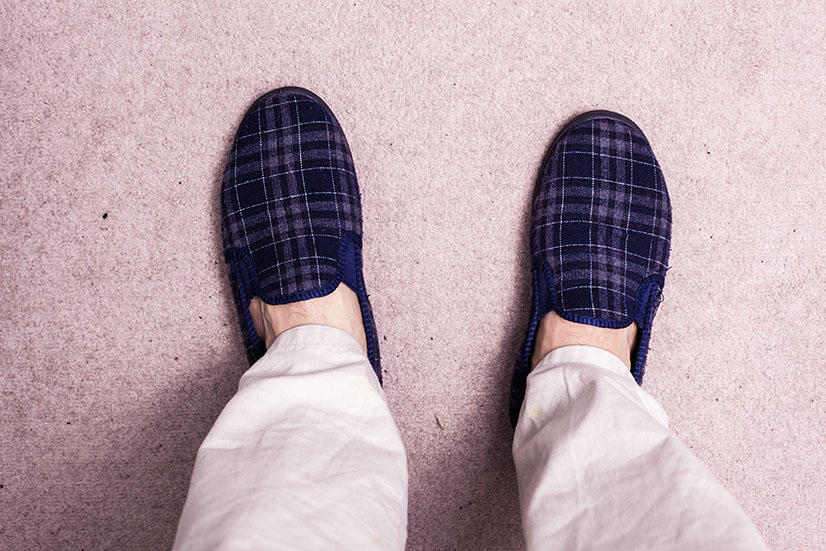 Feet wearing slippers on carpet electrician wirral